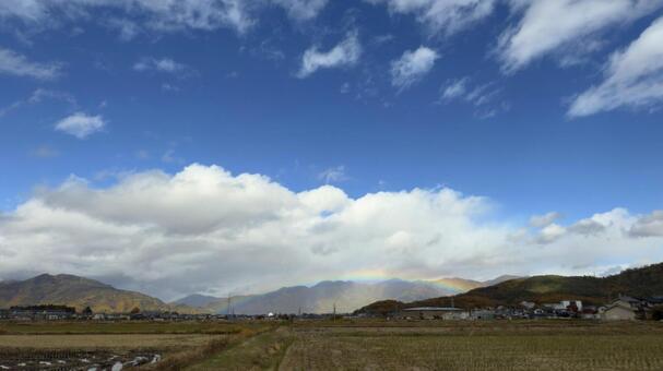 紅葉の山と街に虹がかかる幻想的な風景 虹,レインボー,街の写真素材