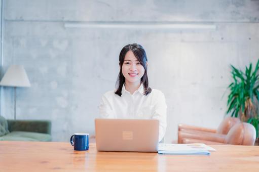 オフィスでパソコンを使う若い女性 オフィスでパソコンを使う若い女性 カフェ,データ,職場の写真素材