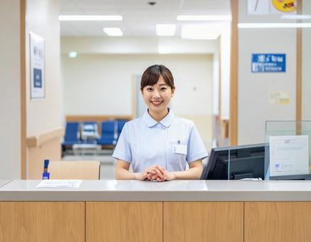 病院の受付コーナーで笑顔で迎える受付嬢 病院の受付コーナーで笑顔で迎える受付嬢の写真