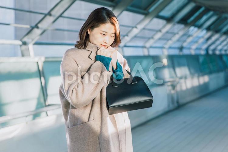 外で寒そうに震えるコートを着た女性 冬,寒い,凍えるの写真素材