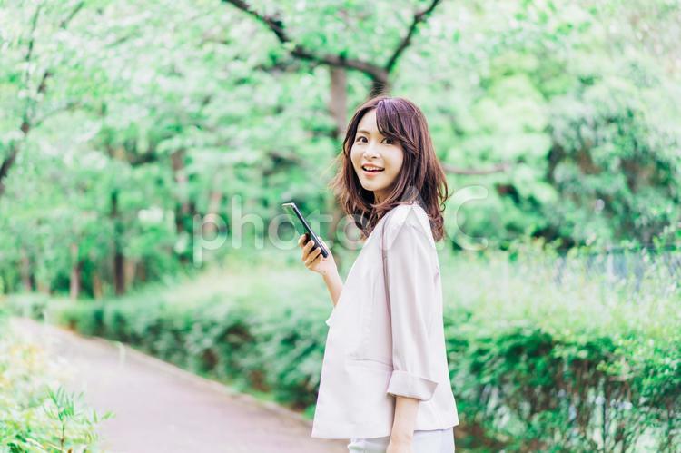 外でスマホを使うビジネスウーマン 生活,会社,snsの写真素材