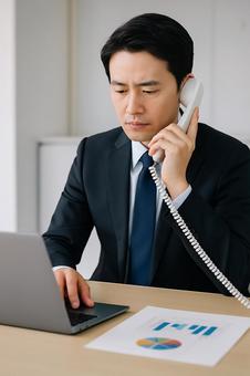 電話対応をする男性社員 電話対応をする男性社員の写真