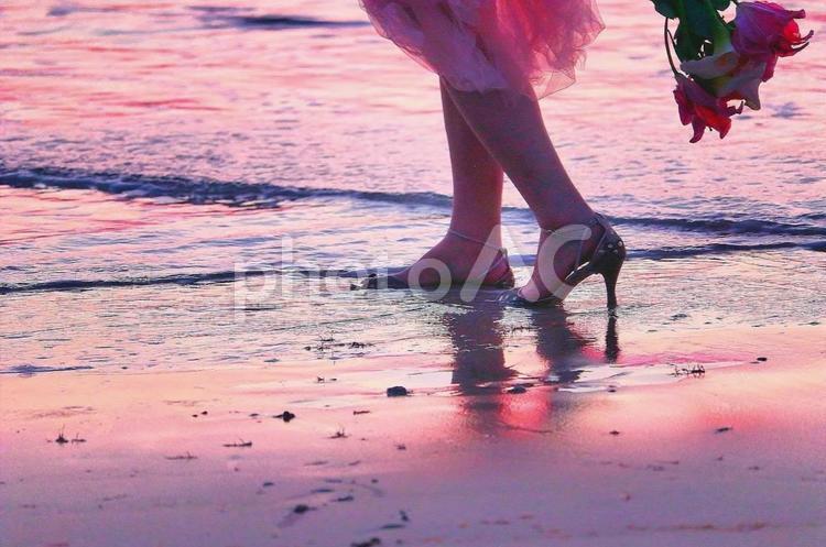 夕暮れの浜辺でお散歩 女性,サンダル,浜辺の写真素材