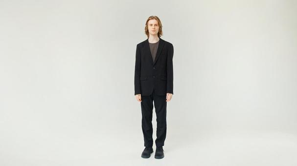 カメラ目線で立つ黒スーツ男性 カメラ目線で立つ黒スーツ男性の写真