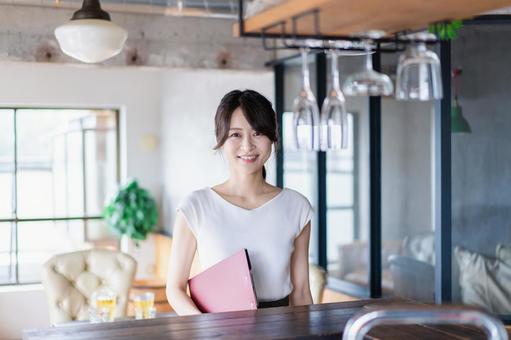 カフェで働く若い女性スタッフ カフェで働く若い女性スタッフの写真