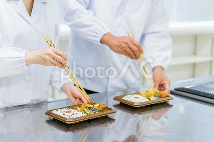 お弁当の盛り付けをする男女（食品加工） お弁当,食品加工,社員食堂の写真素材