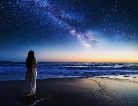 星空と海と女性のシルエット 星空と海と女性のシルエットの写真