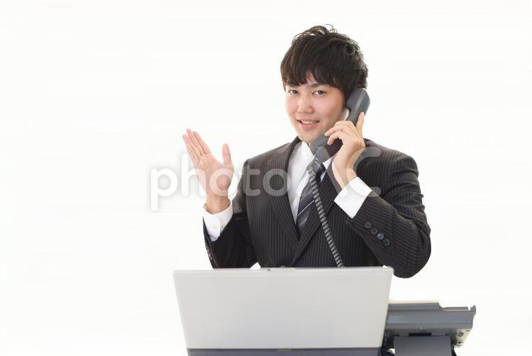 受話器を持つ笑顔のビジネスマン 男性,男,パソコンの写真素材