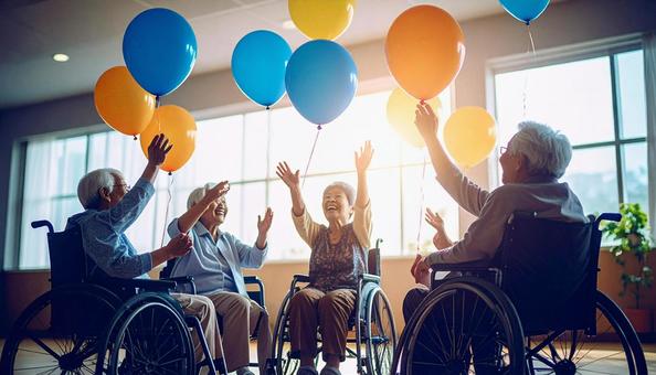 椅子に座り楽しそうに風船バレーをする患者 椅子に座り楽しそうに風船バレーをする患者の写真