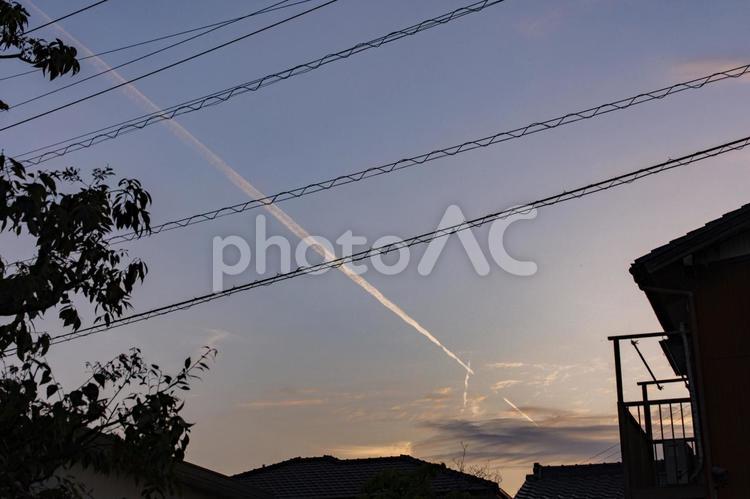 日没の空と家々のシルエット 夕焼け,飛行機雲,空の写真素材