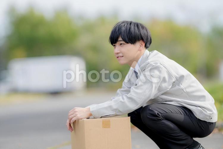 しゃがむ作業服男性 男性,作業着,仕事着の写真素材
