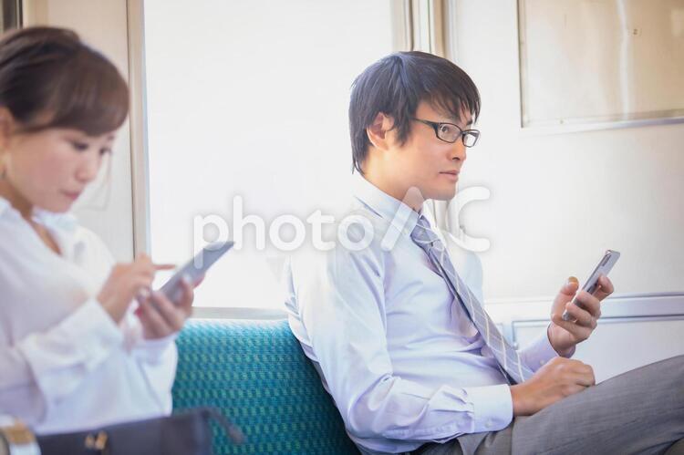 電車に乗る男性 電車に乗る男性 電車,スマホ,ビジネスマンの写真素材