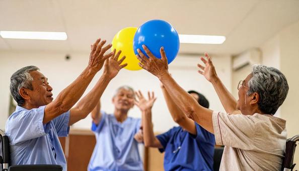 椅子に座り楽しそうに風船バレーをする患者 椅子に座り楽しそうに風船バレーをする患者の写真