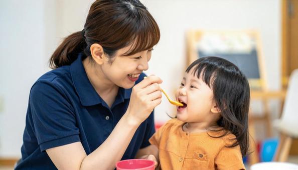 子どもにご飯をあげる保育士 子どもにご飯をあげる保育士の写真