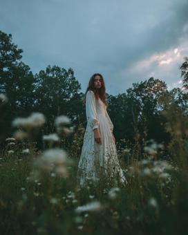 夕暮れの草原に佇む神秘的な女性 夕暮れの草原に佇む神秘的な女性の写真