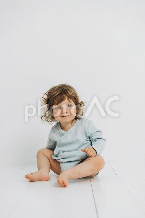 笑顔でお座りする男の子 赤ちゃん,かわいい,笑顔の写真素材