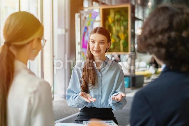 オフィスのラウンジで男女に向かって話している性 ビジネス,グループ,ビジネスマンの写真素材