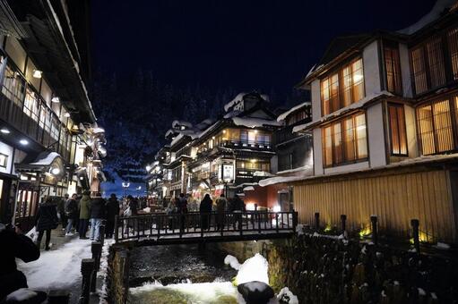 雪の温泉街を散策する観光客 温泉街,夜景,雪の写真素材