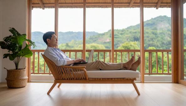 自宅のソファーでテレワークするミドル男性 自宅のソファーでテレワークするミドル男性の写真
