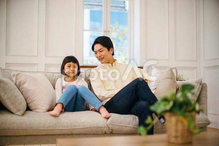 仲良くソファに座る父と娘 父子,親子,女の子の写真素材