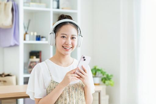 音楽を聴く若い女性 音楽を聴く若い女性 音楽,スマホ,笑顔の写真素材