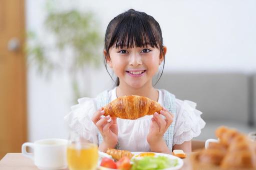 パンを両手に持つ少女 女の子,食事,クロワッサンの写真素材
