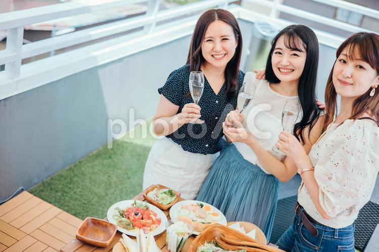 屋上でパーティーをする女性たち（シャンパン） 女子会,パーティー,ホームパーティーの写真素材