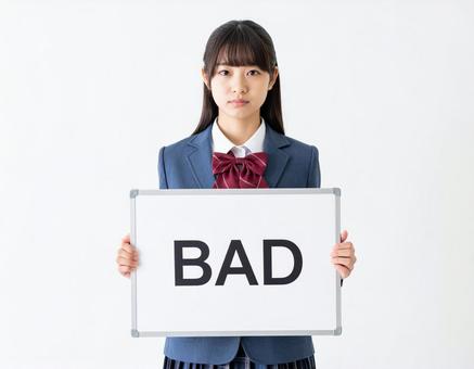 BADと書いたボードをもつ女子生徒 BADと書いたボードをもつ女子生徒の写真