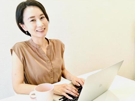 女人微笑著在電腦上工作, JPG 女人微笑著在電腦上工作, JPG