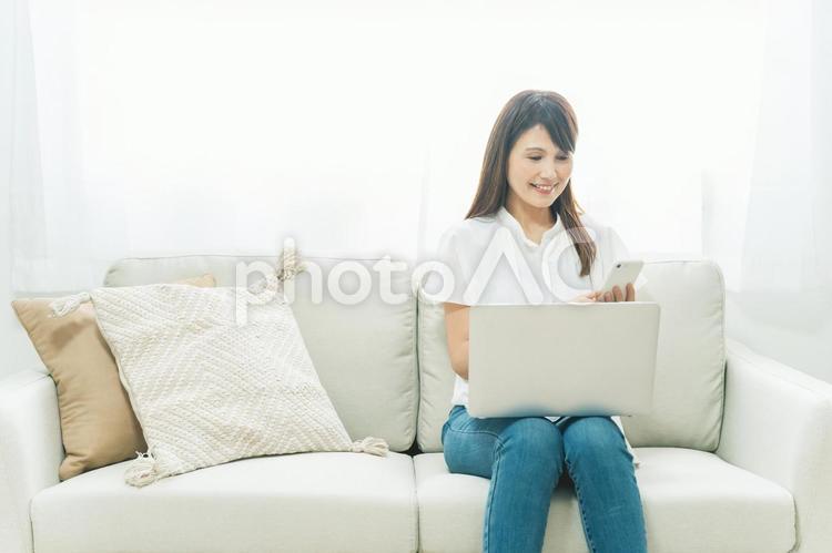 パソコンとスマホを使うミドル世代の女性 スマホ,テレワーク,スマートフォンの写真素材