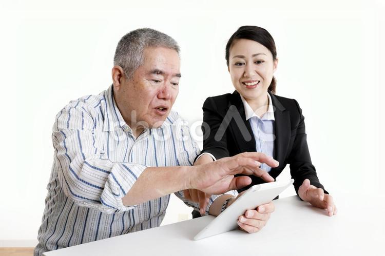 タブレット端末の操作を教えてもらっているシニア男性 高齢者,男性,日本人の写真素材