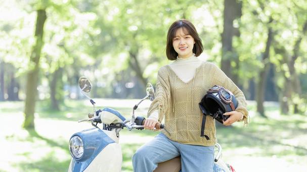 バイクに乗る若い女性 バイクに乗る若い女性 バイク,女性,スクーターの写真素材