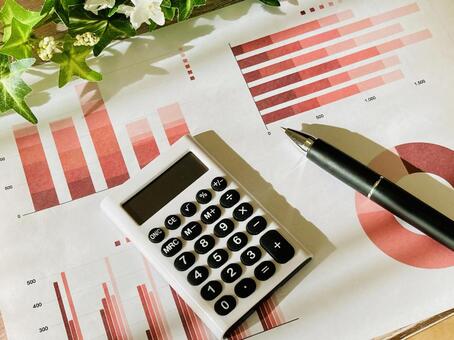 赤いグラフ資料と電卓、ボールペン グラフ,電卓,分析の写真素材