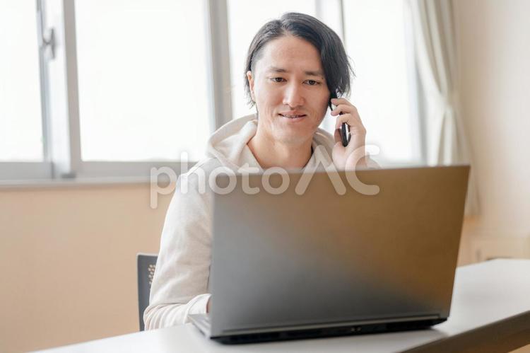 PCと電話する私服男性 男性,日本人,若者の写真素材