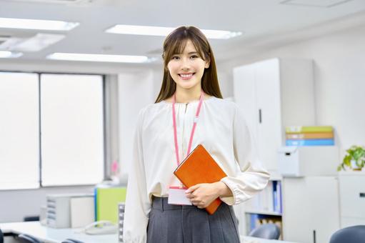 オフイスで手帳を持つ笑顔の若い女性社員 ビジネスウーマン,笑顔,オフィスの写真素材