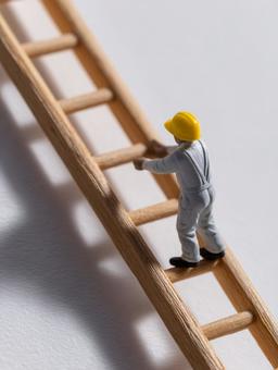 木のはしごを登る小さな建設作業員 木のはしごを登る小さな建設作業員の写真