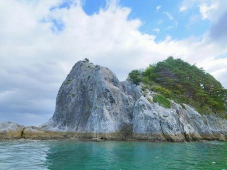 エメラルドグリーンの海に浮かぶ大きな岩 海,海辺,海に生える木の写真素材