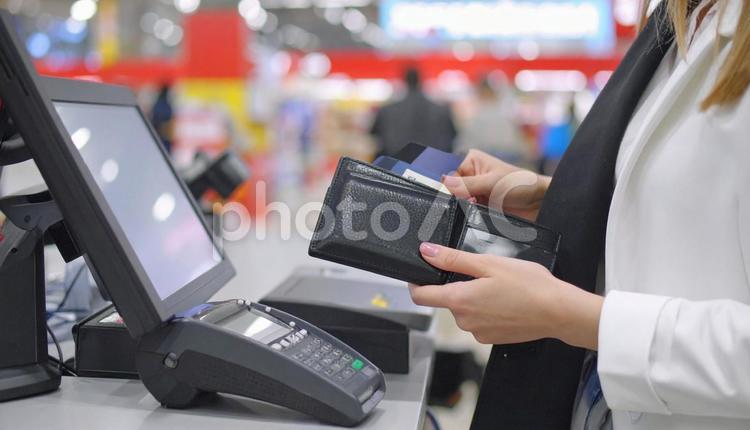 財布からクレジットカードを出す女性の手元 クレジットカード,ビジネスウーマン,ビジネスパーソンの写真素材
