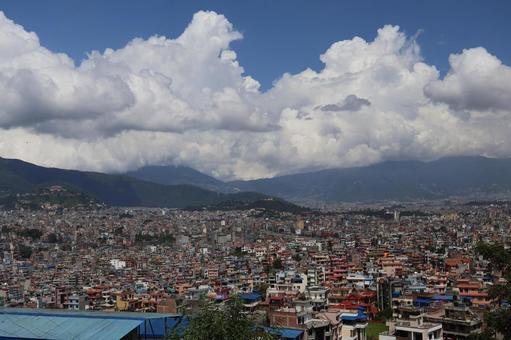 白い雲と青空と山並みとカトマンズの街並みの写真
