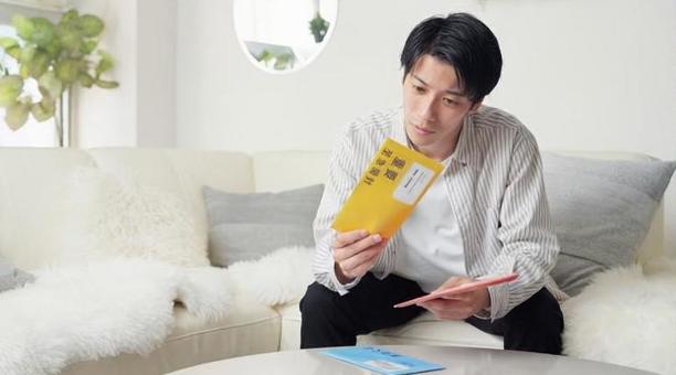 督促状を確認するアジア人男性 督促状,催促,封筒の写真素材