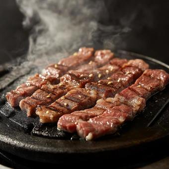 鉄板でジューシーに焼かれる牛肉のアップ 鉄板でジューシーに焼かれる牛肉のアップの写真