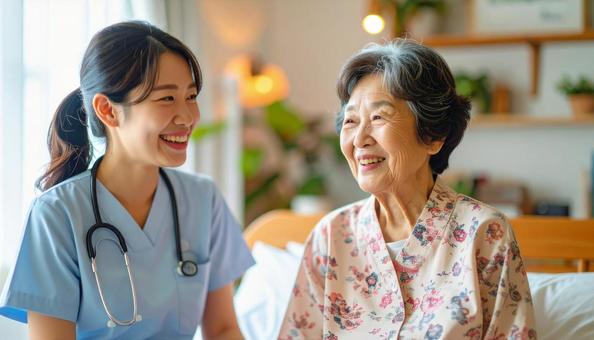 笑顔で話をする女性介護士と高齢女性の写真