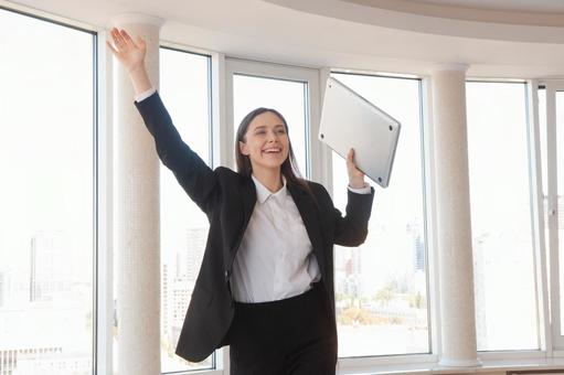 パソコンを持ち呼びかける女性 女性,外国人,ノートパソコンの写真素材