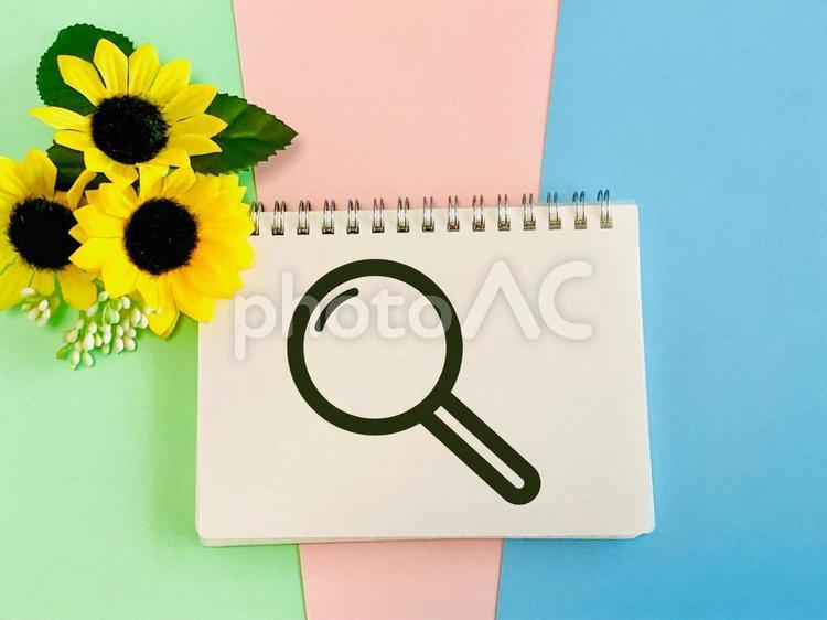 虫眼鏡の絵が書かれたノートと向日葵 虫眼鏡,向日葵,ノートの写真素材