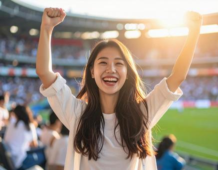 スタジアムで勝利を喜ぶ女性 スタジアムで勝利を喜ぶ女性の写真