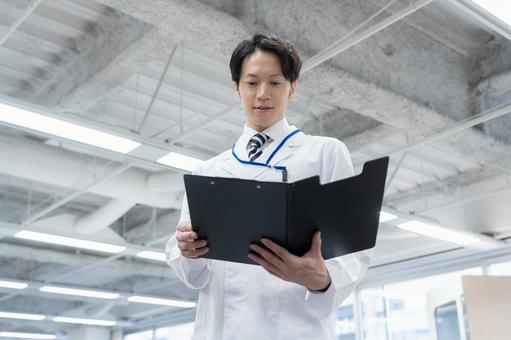 実験をする白衣の若い男性研究者 実験をする白衣の若い男性研究者 研究,実験,サイエンスの写真素材