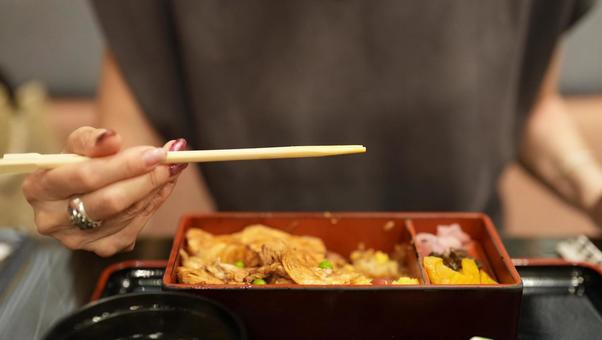 お重を食べる女性 お重を食べる女性の写真