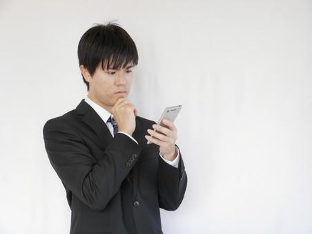 20-year-old male businessman worried looking at smartphone 20-year-old male businessman worried looking at smartphone