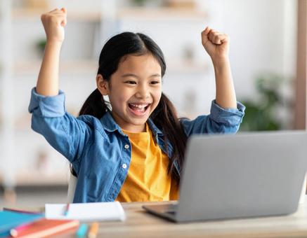 オンライン学習で喜ぶ笑顔の女の子 オンライン学習で喜ぶ笑顔の女の子の写真