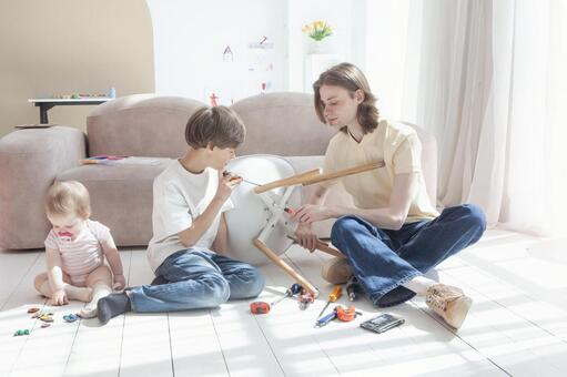 リビングで子供と家具を組み立てる若い父親 親子,diy,男の子の写真素材